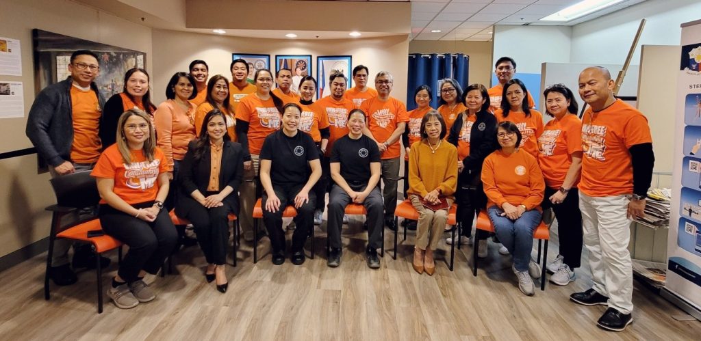 The men and women of the Philippine Consulate General in Vancouver, led by Consul General Arlene Magno, with VPD-WPST resource speakers, wear orange, which represents hope and a future free from violence against women and girls. (Photo by Vancouver PCG)